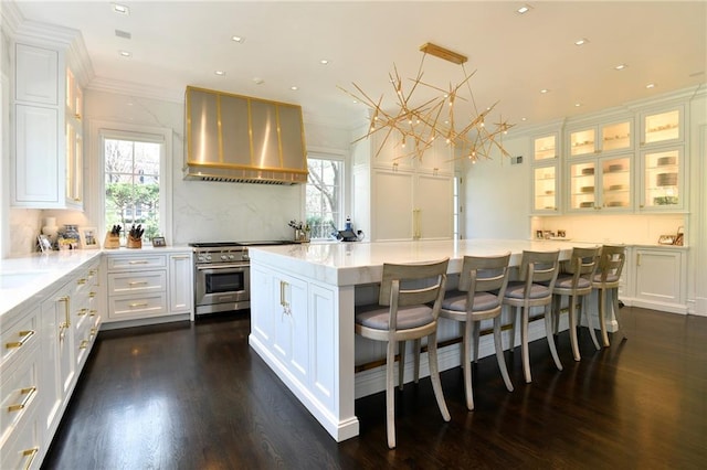 kitchen featuring dark hardwood / wood-style floors, a center island, wall chimney exhaust hood, and white cabinetry