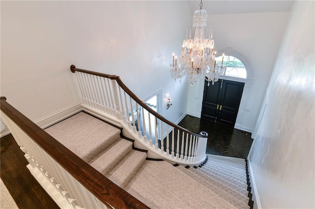 foyer entrance with a high ceiling, a notable chandelier, and dark hardwood / wood-style floors