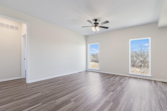 spare room with dark hardwood / wood-style flooring and ceiling fan