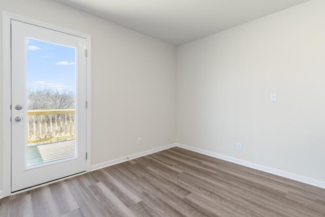 empty room with dark hardwood / wood-style flooring and a healthy amount of sunlight