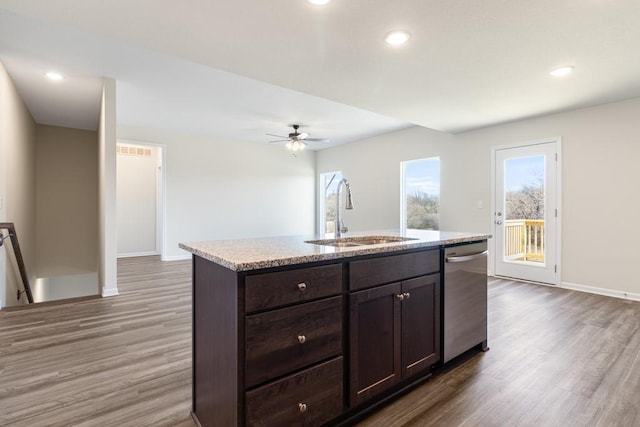 kitchen with ceiling fan, a center island with sink, dishwasher, sink, and dark hardwood / wood-style floors