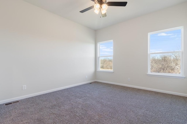 unfurnished room featuring ceiling fan and dark carpet