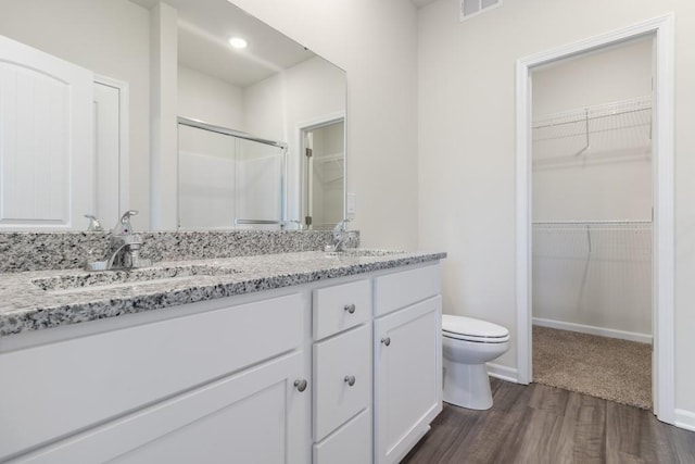 bathroom with toilet, hardwood / wood-style flooring, and dual bowl vanity