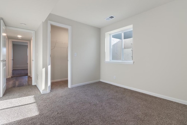 unfurnished bedroom with a closet, a walk in closet, and carpet