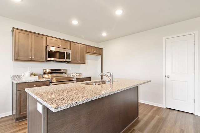 10298 Lucca Ln, Peculiar, MO 64078 - kitchen with appliances with stainless steel finishes, a sink, wood finished floors, baseboards, and recessed lighting