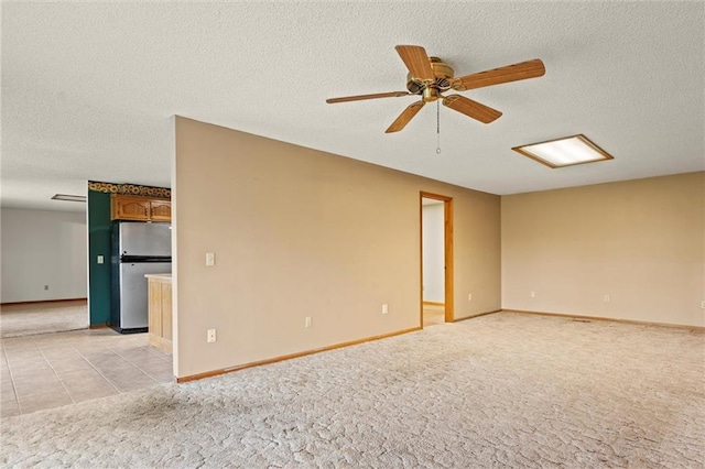 tiled empty room featuring ceiling fan and a textured ceiling