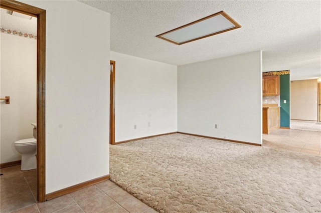 carpeted empty room featuring a textured ceiling