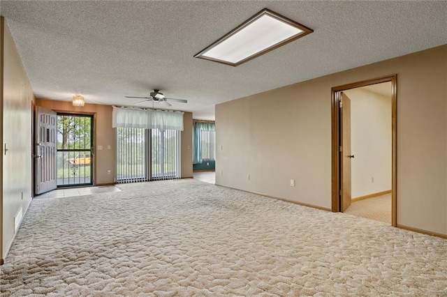 carpeted spare room featuring ceiling fan and a textured ceiling