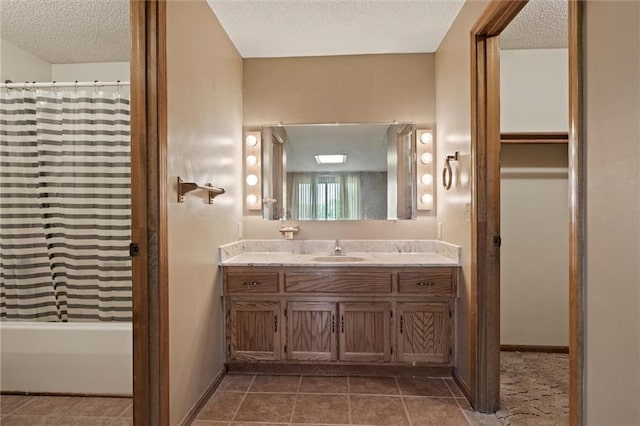 bathroom with shower / bathtub combination with curtain, tile flooring, vanity, and a textured ceiling