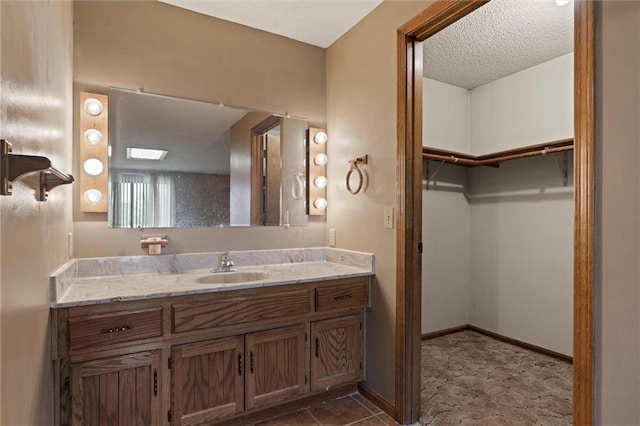 bathroom with tile flooring, vanity, and a textured ceiling