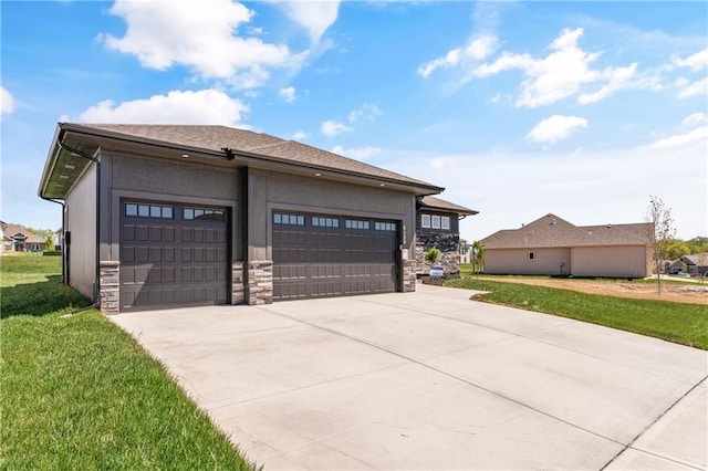 prairie-style house featuring a front lawn, an outdoor structure, and a garage