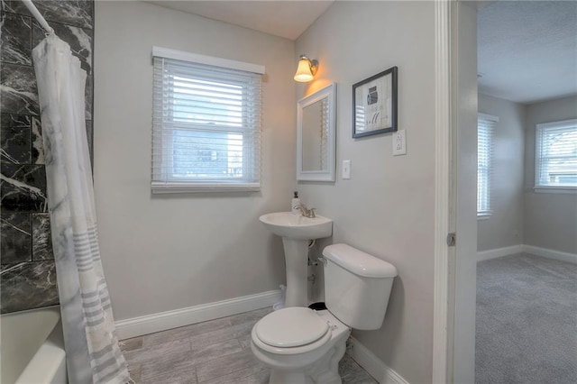 bathroom featuring shower / bath combination with curtain and toilet