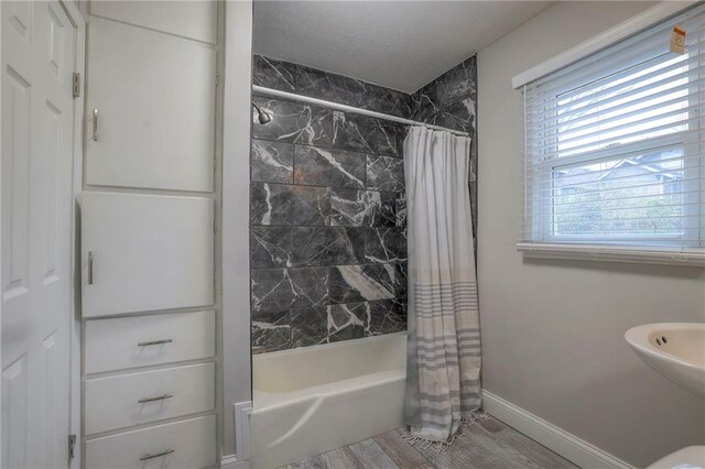 bathroom featuring shower / tub combo with curtain and hardwood / wood-style flooring