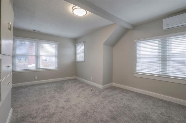 bonus room featuring light carpet, a wall mounted AC, and beamed ceiling