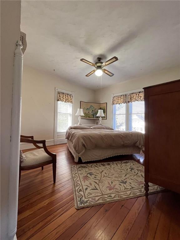 bedroom with ceiling fan and dark hardwood / wood-style floors