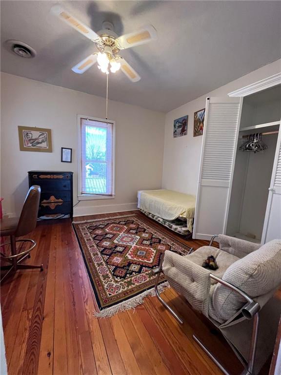 living room featuring ceiling fan and dark hardwood / wood-style flooring