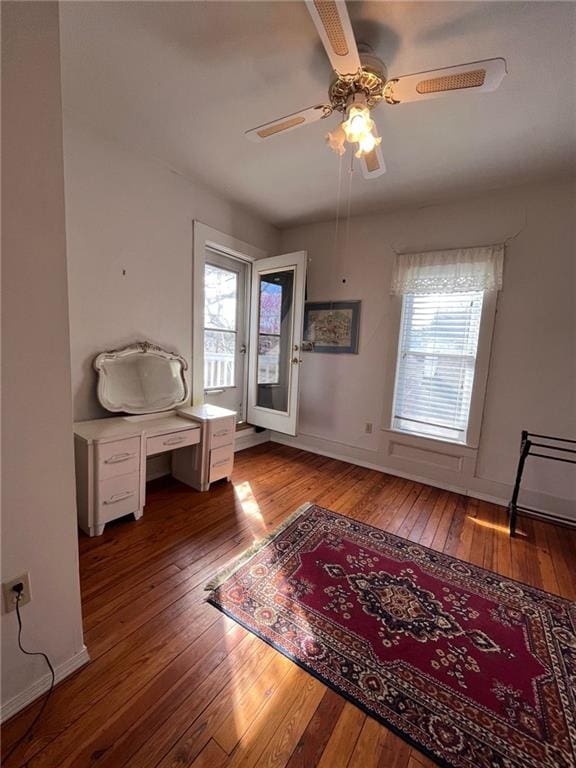 unfurnished bedroom featuring hardwood / wood-style floors, ceiling fan, and multiple windows