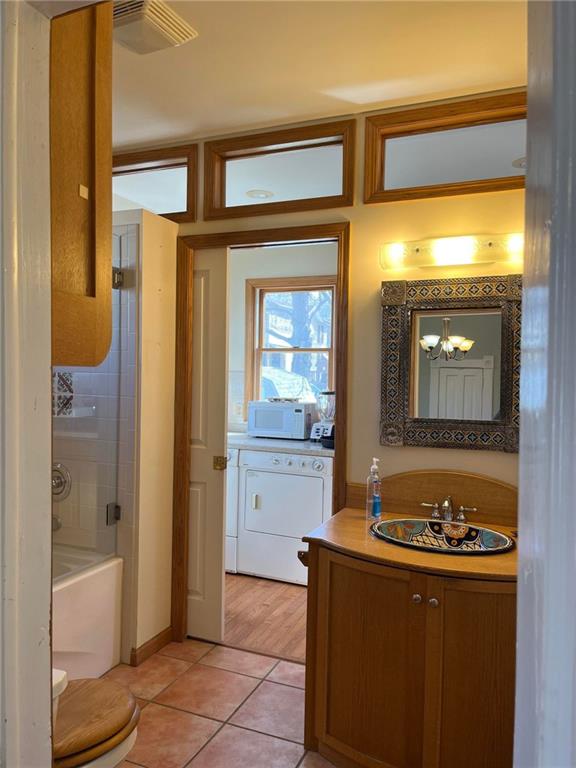 full bathroom with wood-type flooring, shower / washtub combination, toilet, and vanity with extensive cabinet space