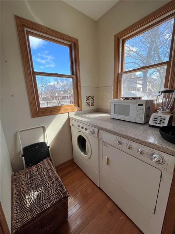 laundry area featuring washing machine and dryer and wood-type flooring