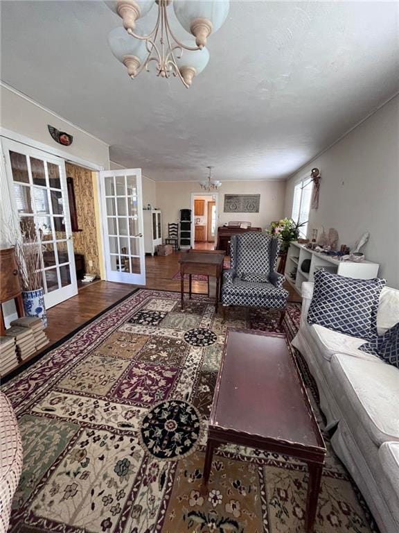 living room with dark hardwood / wood-style floors, an inviting chandelier, and french doors