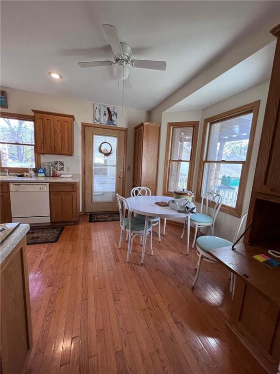 kitchen featuring light hardwood / wood-style flooring, tasteful backsplash, ceiling fan, and dishwasher