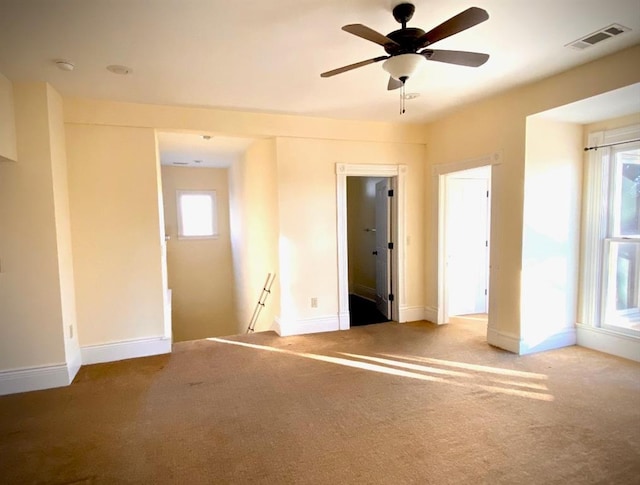 carpeted spare room with plenty of natural light and ceiling fan