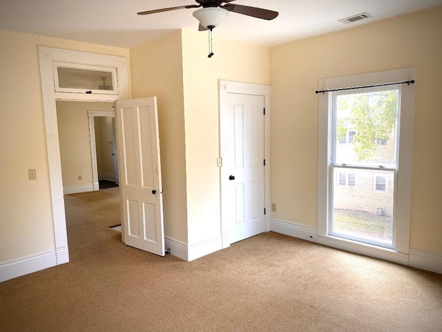 interior space with light carpet and ceiling fan