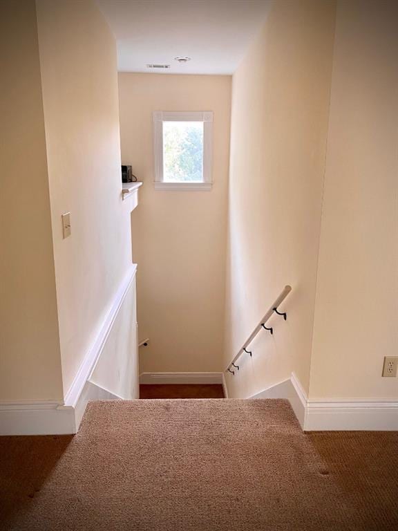 stairs featuring dark carpet