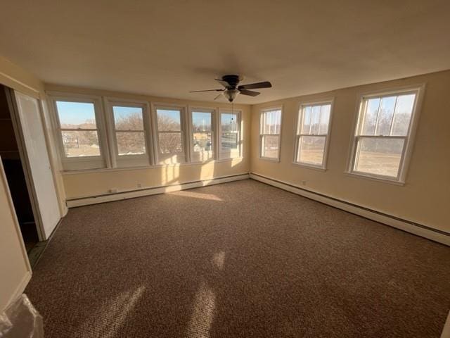 unfurnished room featuring ceiling fan and dark colored carpet