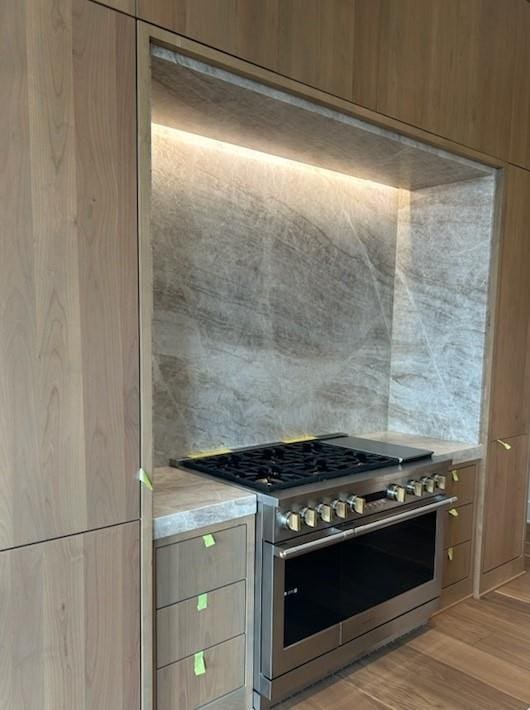 kitchen with high end stainless steel range oven and light wood-type flooring