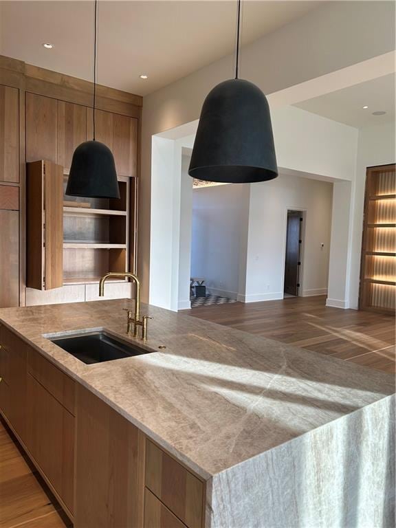 kitchen with hardwood / wood-style floors, pendant lighting, and sink