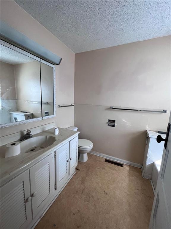 bathroom featuring toilet, a textured ceiling, and vanity