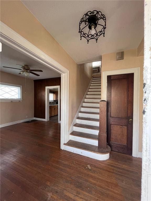 stairs with ceiling fan and dark wood-type flooring