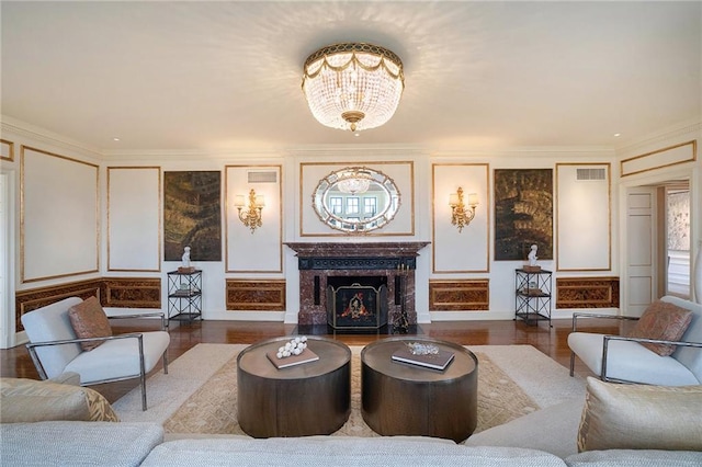 living room with ornamental molding, a notable chandelier, and hardwood / wood-style floors