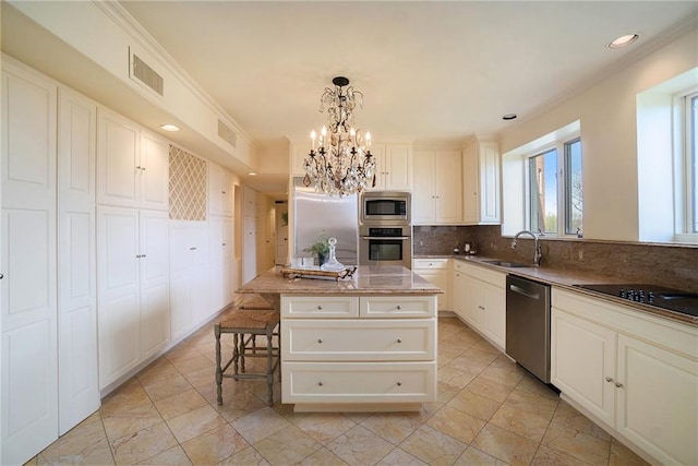 kitchen featuring decorative backsplash, ornamental molding, pendant lighting, a notable chandelier, and appliances with stainless steel finishes