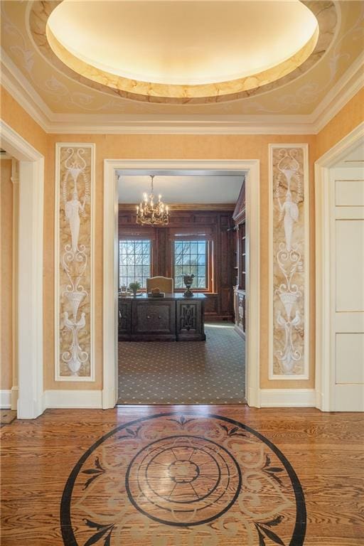 corridor with a tray ceiling, crown molding, and hardwood / wood-style floors