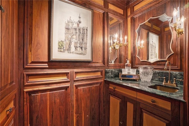 bathroom featuring sink and wooden walls