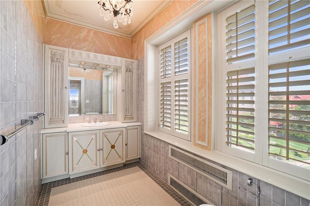 bathroom with tile patterned flooring, tile walls, vanity, and an inviting chandelier