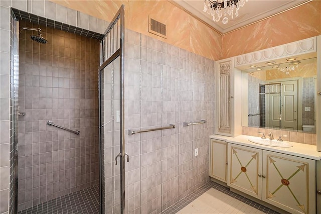 bathroom with vanity, tile walls, an enclosed shower, and tile patterned floors