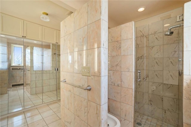 bathroom featuring tile patterned floors, a shower with door, and tile walls