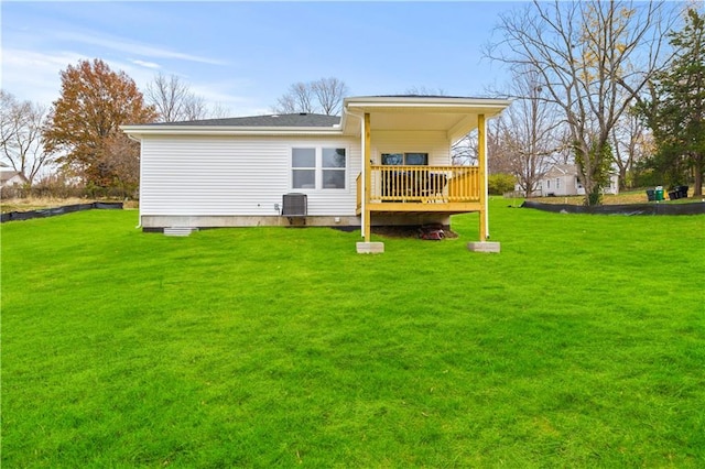 rear view of property with a yard, cooling unit, and a deck