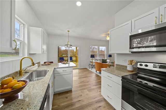 kitchen featuring light stone counters, sink, white cabinetry, and stainless steel appliances