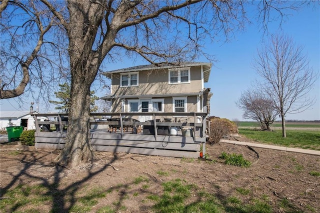 back of house featuring a wooden deck and a rural view