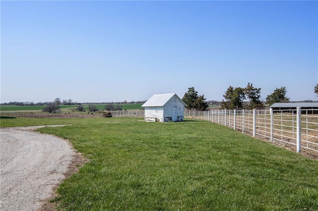 view of yard with an outbuilding and a rural view