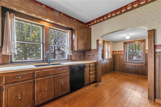 kitchen with dishwasher, a healthy amount of sunlight, sink, and light wood-type flooring