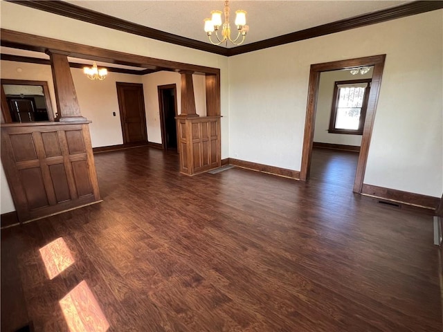 unfurnished room with dark hardwood / wood-style floors, an inviting chandelier, crown molding, and ornate columns