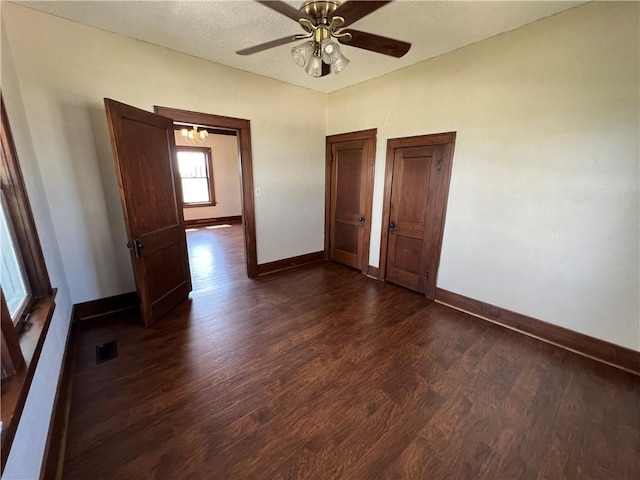 unfurnished bedroom featuring a textured ceiling, dark wood-type flooring, and ceiling fan