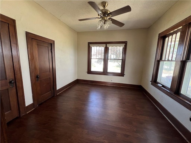 unfurnished room featuring dark hardwood / wood-style flooring, ceiling fan, and a textured ceiling