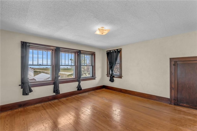 spare room featuring a textured ceiling and light wood-type flooring