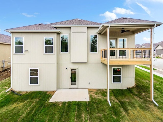 back of property featuring ceiling fan, a yard, roof with shingles, and a patio area